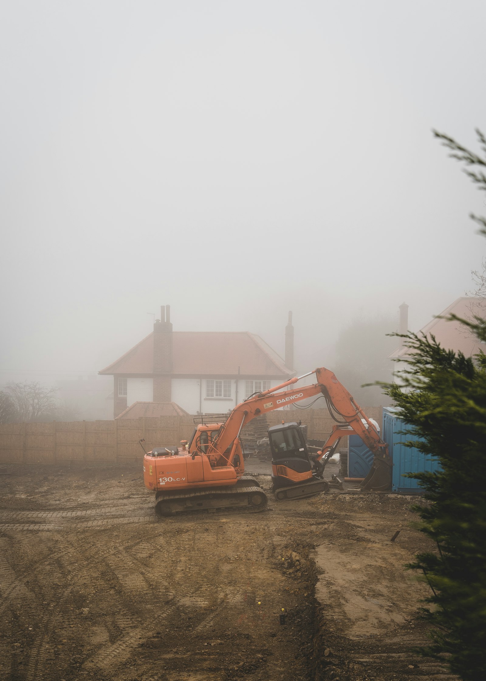 Excavator working on a plot in fog